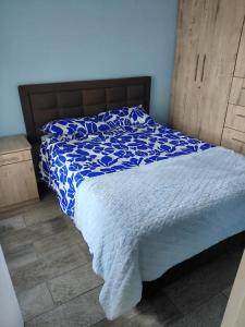 a bedroom with a bed with a blue and white comforter at Unit 8 Hermanus Beach Club in Hermanus