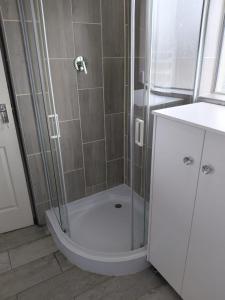 a shower with a glass door next to a sink at Unit 8 Hermanus Beach Club in Hermanus