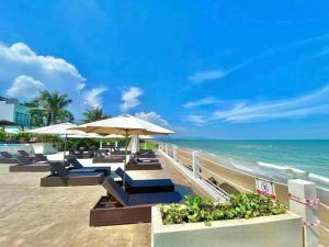 a beach with chairs and umbrellas and the ocean at Căn Hộ Vũng Tàu in Xa Thang Nhut