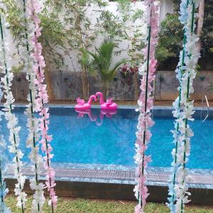 a pool with two pink flamingos in the water at moments hotel & restaurant in Hikkaduwa