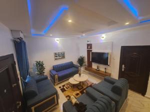 a living room with a couch and a tv at Oghomwen Lodge and Service Apartment in Benin City