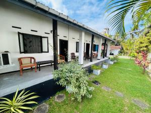 a white house with a patio and a yard at moments hotel & restaurant in Hikkaduwa