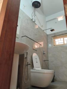 ein Badezimmer mit Toilette und Waschbecken in der Unterkunft Tribal Hostel & Homestay in Guwahati + 11 Fotos