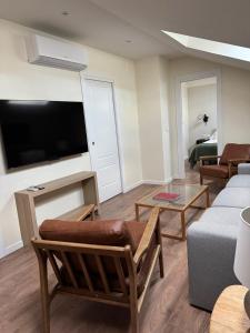 a living room with a couch and a tv at Galatea LibroVI Apartamento con arte en sus muros in Alcalá de Henares