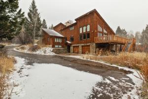 a house in the snow with a pond in front of it at RMR: Teodori House in Teton Village in Teton Village