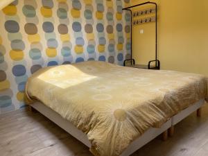 Bett in einem Zimmer mit gelber Tagesdecke in der Unterkunft Près d'Etretat, joli appartement pour 4 personnes avec 2 chambres, vous pouvez me contacter sur Les gîtes de SoleilMapou in Bec-de-Mortagne