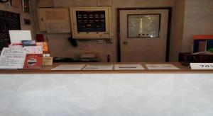 a counter with a door in a office with papers on it at Sento Otani Hotel in Toyooka