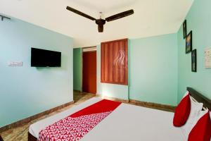 Un dormitorio con una cama y un televisor de pantalla plana. en Hotel O 27 Degree Hotel, en Dhanbād