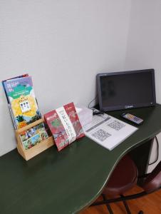 那覇市にあるリンゴテラス壺屋のノートパソコンと本が置かれた緑色の机