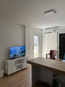 Una habitación blanca con un escritorio y un televisor encima. en Vilimon, en Prokuplje