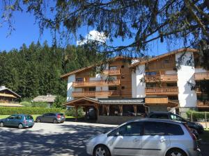 a building with cars parked in front of it at Hôtel Rent in Megève
