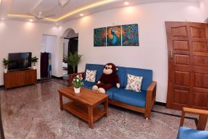 - un ours en peluche assis sur un canapé bleu dans le salon dans l'établissement 2BHk Peacock in North Goa, à Porvorim