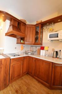 una cucina con mobili in legno e un lavello di Ramresort Apartment a Birštonas