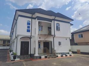 a white house with a balcony on top of it at Oghomwen Lodge and Service Apartment in Benin City