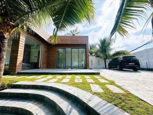 une maison avec une voiture garée devant dans l'établissement Biển tôm ốc homestay hồ bơi & BBQ garden, à Xóm Bình Nguyên