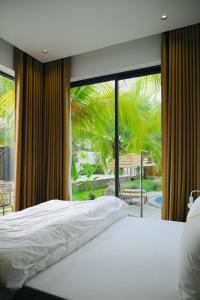 une chambre avec un lit blanc et une grande fenêtre dans l'établissement Biển tôm ốc homestay hồ bơi & BBQ garden, à Xóm Bình Nguyên 69 autres photos