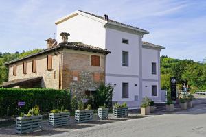 a large white building with a roof at Pietralunga Resort in Fidenza