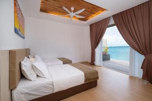 une chambre avec un lit avec vue sur l'océan dans l'établissement Sand Bay Resort Semporna, à Pulau Sabangkat
