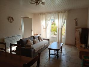a living room with a couch and a table at Les Jardins des 3 Provinces- Gîte in Montcharvot