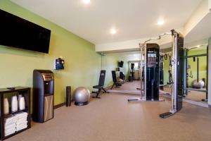 Ein Fitnessraum mit Turnhalle, Fernseher und Simulator in der Unterkunft WoodSpring Suites Panama City Beach in Panama City Beach