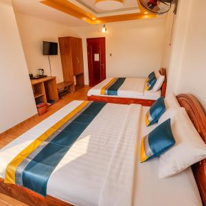 a room with two beds and a tv at Trung Hiếu Hotel - bên cạnh Miếu Bà Chúa Xứ in Chau Doc