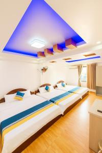 two beds in a room with a blue ceiling at Trung Hiếu Hotel - bên cạnh Miếu Bà Chúa Xứ in Chau Doc