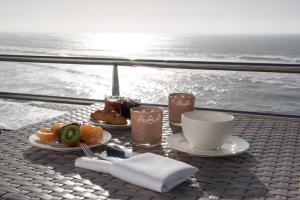 a table with plates of food and coffee and the ocean at Atlantic Hôtel & Spa in Les Sables-d'Olonne