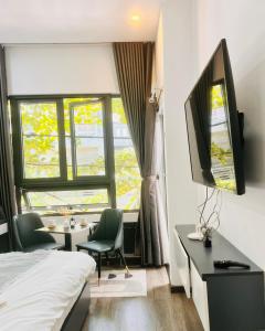 een slaapkamer met een bed, een bureau en een tv bij Levi Living in Da Nang