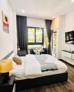 een slaapkamer met een groot wit bed en een raam bij Levi Living in Da Nang