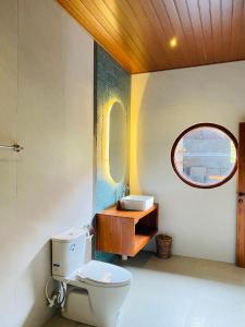 een badkamer met een toilet, een wastafel en een spiegel bij Karunia House Ubud in Ubud +37 foto's