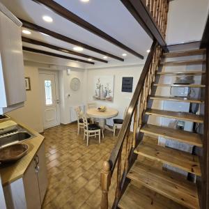 a kitchen and a dining room with a table and stairs at Villa Bacchus Kassiopi Corfu in Kassiopi