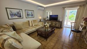 a living room with a couch and a table at Villa Bacchus Kassiopi Corfu in Kassiopi