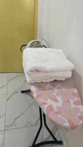 a stack of towels sitting on a stool in a bathroom at Rest N Go CM in Ipoh