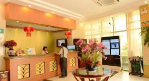 a woman is standing at a cash register in a store at GreenTree Inn Shanghai Waigaoqiao Free Trade Zone Express Hotel in Shanghai