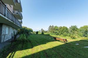 a park bench sitting in the grass next to a building at Zenitude Evian Les Terrasses du Lac, an Ascend Collection Hotel in Évian-les-Bains
