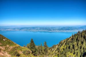 a view of a blue lake from the top of a mountain at Zenitude Evian Les Terrasses du Lac, an Ascend Collection Hotel in Évian-les-Bains