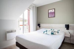 a bedroom with a bed and a large window at Comfort Aparthotel Nantes La Beaujoire in Nantes +72 photos