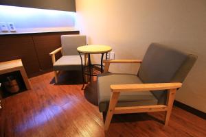 una sala de espera con 2 sillas y una mesa en The Ace Hotel, en Seúl