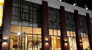 Un edificio con grandes ventanales y luces encendidas. en The Regent Ubon, en Ban Na Khwai