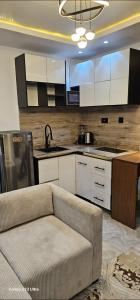a living room with a couch in front of a kitchen at Ladi's Place 2, Anthony, Ikeja in Lagos