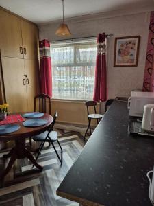 a kitchen with a table and chairs and a window at Amarillys Guest House in Preston