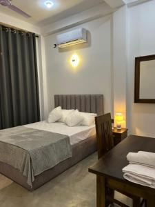 a bedroom with a bed and a table and a window at Tropictide Weligama in Nikawatawana