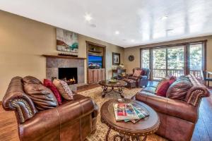 a living room with leather furniture and a fireplace at Lv12: luxury villa walk to the Beach in Glenbrook