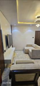 a living room with a couch and a tv at Ladi's Place 2, Anthony, Ikeja in Lagos