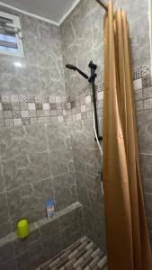 a shower with a shower curtain in a bathroom at Le Studio Marin in Bouéni