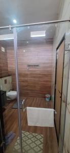 une salle de bain avec une douche en verre et des toilettes dans l'établissement Aavasan home stay, à Davangere