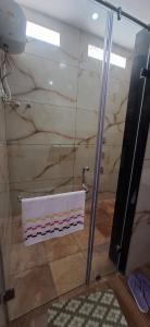 une douche avec une porte vitrée dans une salle de bain dans l'établissement Aavasan home stay, à Davangere