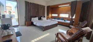 une chambre avec un lit et des chaises dans une pièce dans l'établissement Aavasan home stay, à Davangere