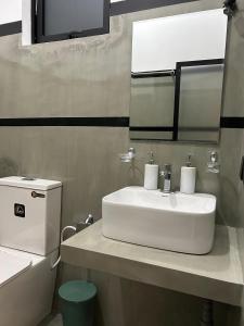 a bathroom with a white sink and a mirror at Tropictide Weligama in Nikawatawana