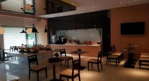 een keuken en eetkamer met tafels en stoelen bij Jinjiang Inn Baoding Baigou Town in Yihezhuang